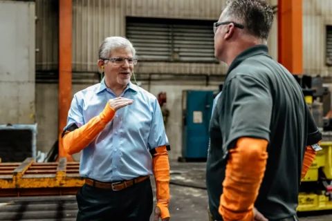 CBS manufacturing consultants background includes Ed (CEO) talking with a client.