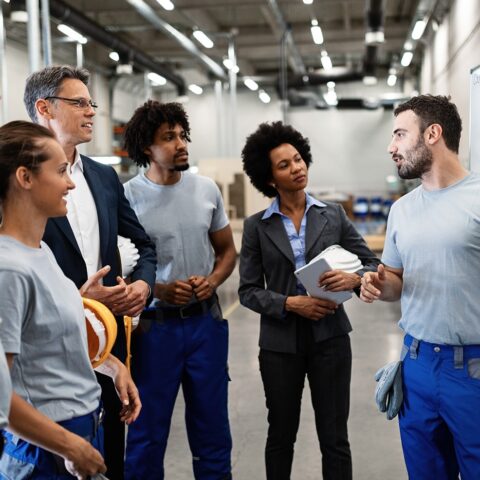 Lean consultants touring a manufacturing facility and listening to employees share about their systems